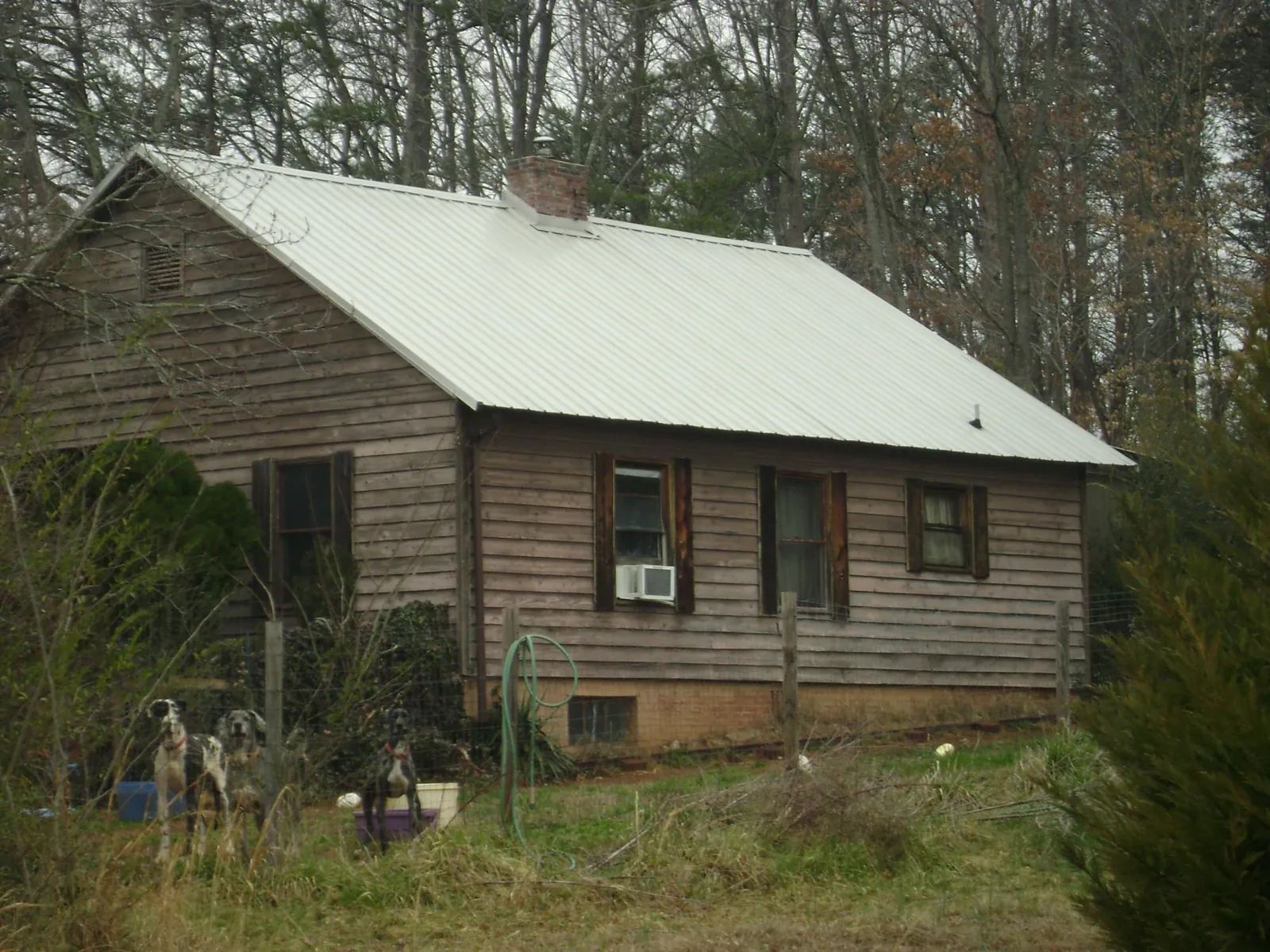 White metal roof on an old wood sided farmhouse, from a Metal Roof Installation job in Clearwater Beach